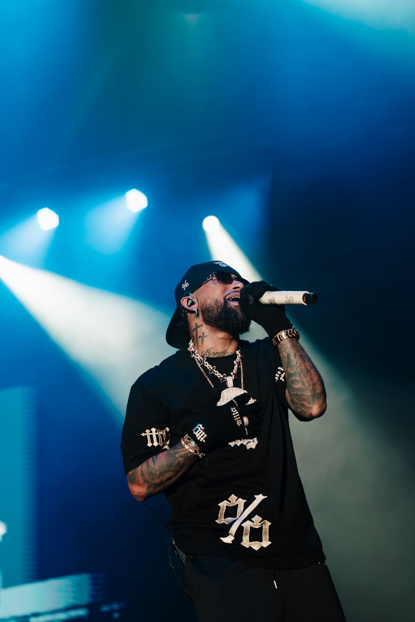 Bryant Myers on stage at Sant Jordi Club wearing the Black Tee with the % and «millo gang» on the sleeve