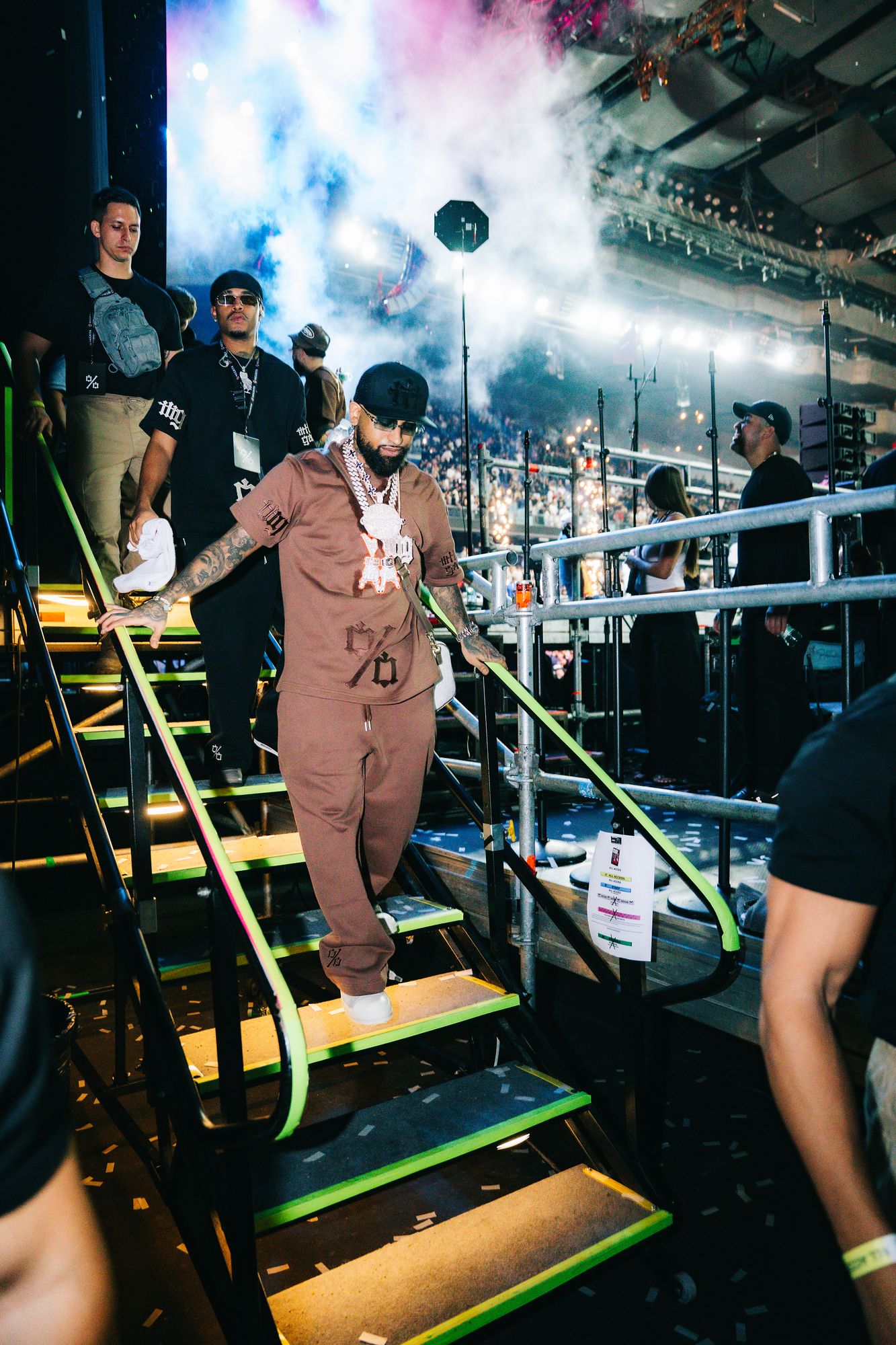 Bryant Myers walks off stage at Movistar Arena wearing the brown Millo Gang set and carrying the monogram bag