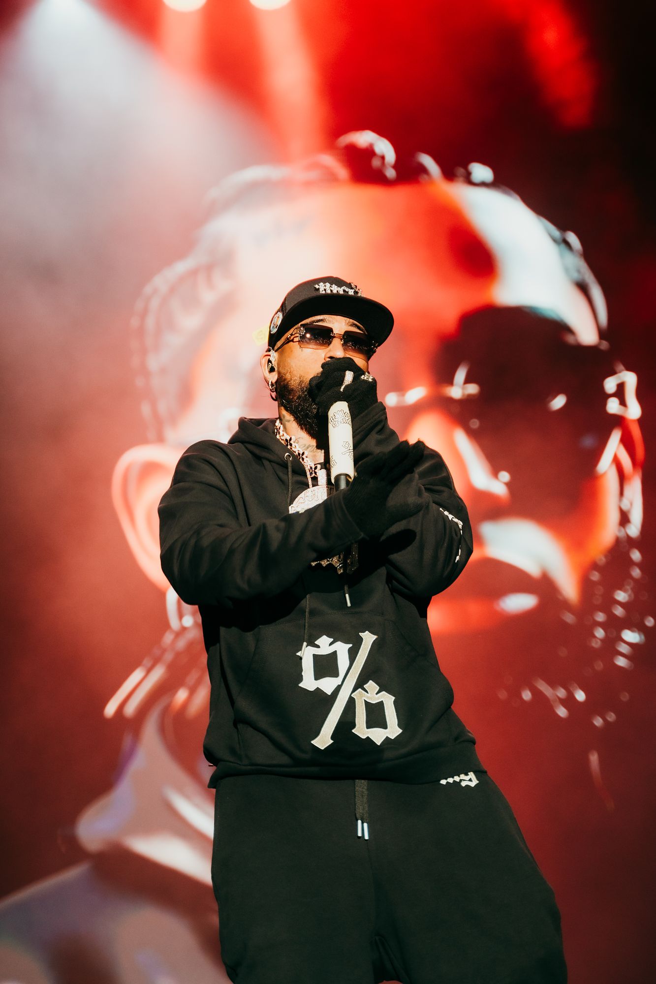 Bryant Myers performs at Roig Arena in Valencia wearing the Millo Gang Black Hoodie with the % embroidered on the chest
