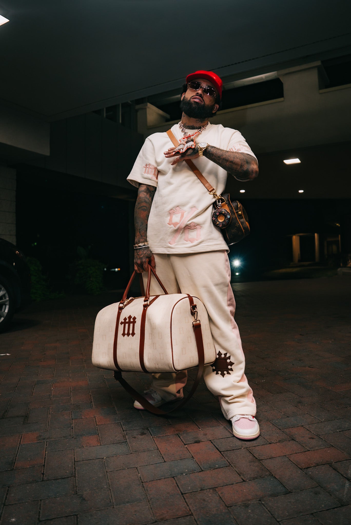 Bryant Myers carrying the large cream Millo Gang bag and wearing his white and cream outfit