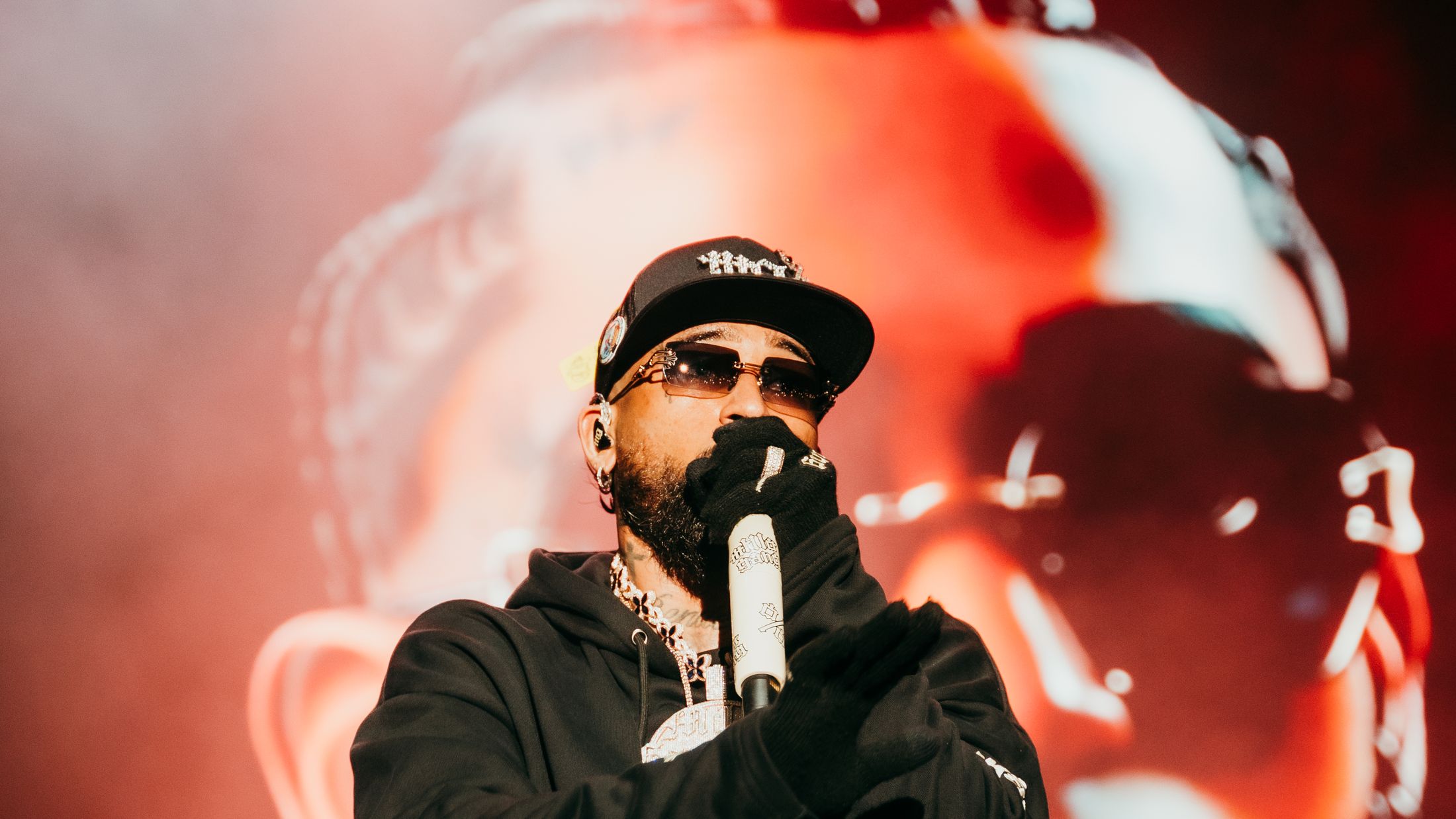 Bryant Myers wearing the black % sweatshirt on stage